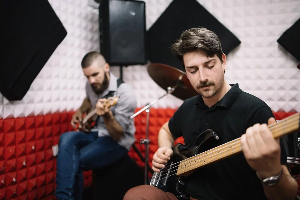 Männer spielen im Musikzimmer Gitarre