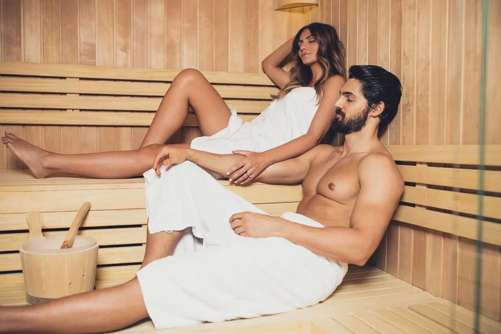 Mit einer Sauna wird das Poolhaus zum Wellnesscenter Paar sitzt in einer Sauna