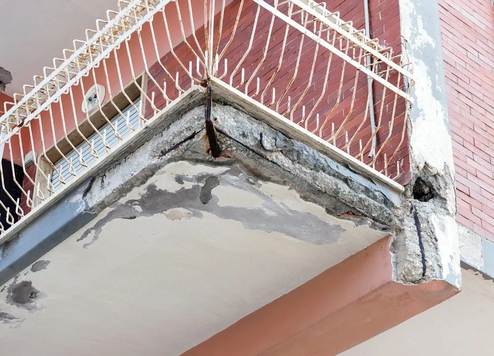 Beton bröckelt von marodem Balkon.