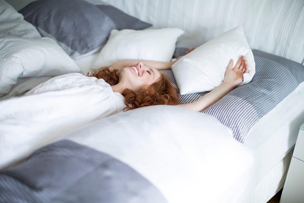 Frau fühlt sich wohl im Bett.