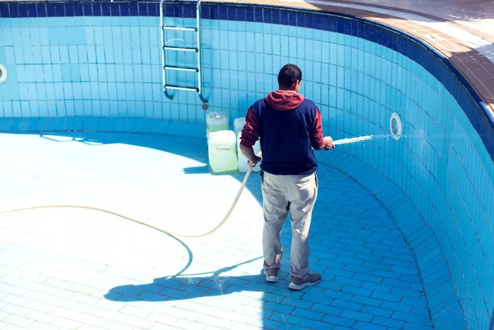 Mann reinigt den Pool von innen Poolreinigung