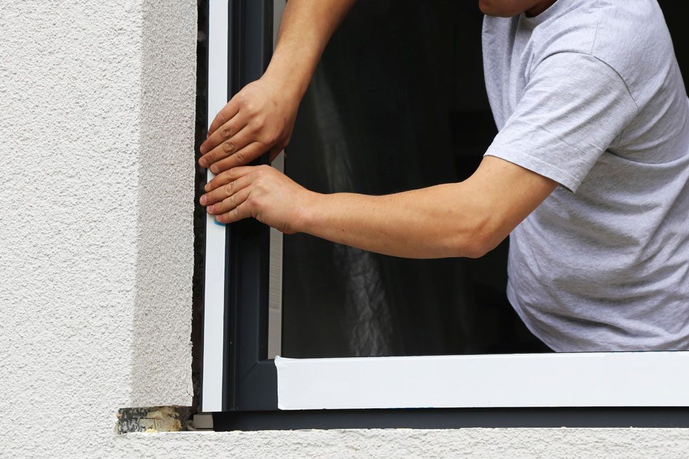 Handwerker baut Fenster ein.