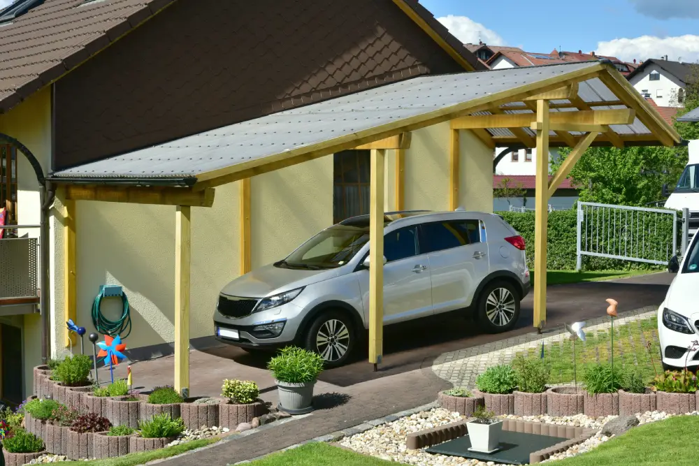 Holzcarport an einem Hang errichtet, angepasst an unebenes Gelände.
